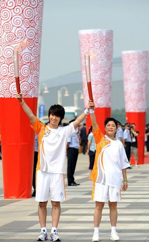 9月1日，第一棒火炬手趙繼紅（右）與下一棒火炬手宋曉波展示火炬。