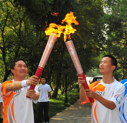 9月2日，火炬手徐孝成（右）與下一棒火炬手張步宏交接