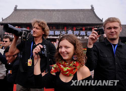  9月19日，几位外国游客在开展仪式上拍照。