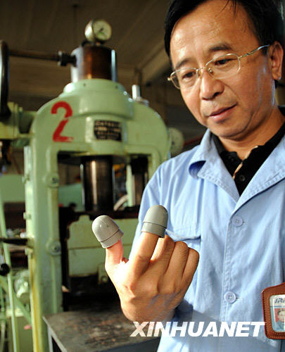 沈阳橡胶研究设计院研究室主任常大勇在展示为“神七”宇航员舱外服研发的“指套”（9月18日摄）。  