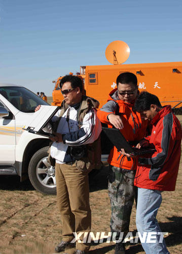 9月25日，新华社摄影记者王建民（左）、文字记者黎云（中）、技术员钱传法在位于内蒙古中部草原的神七着陆场区调试传输设备。当日，新华社神七着陆场区记者组到位。
