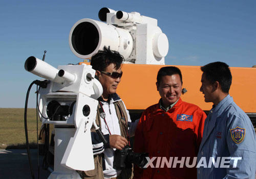 9月25日，新华社记者王建民（左）在位于内蒙古中部草原的神七着陆场采访回收技术人员。