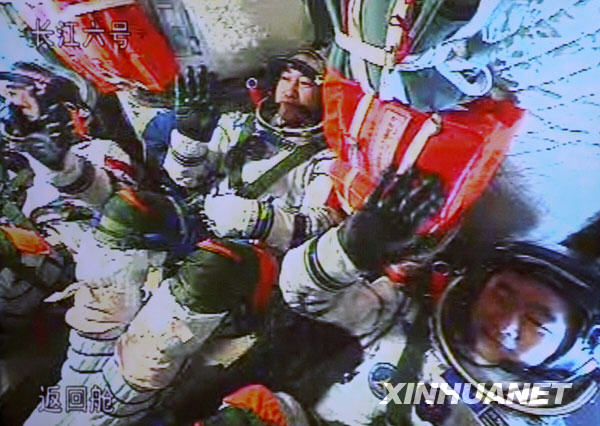 9月28日，航太員翟志剛（中）、劉伯明（右）和景海鵬在神舟七號載人飛船上向地面控制中心工作人員揮手致意（攝于北京航太飛行控制中心大螢幕）。