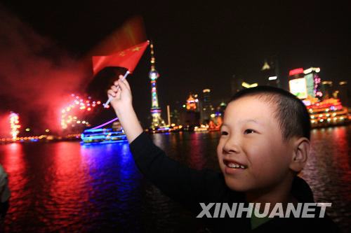 10月3日，一位小朋友正在江邊觀賞彩船巡遊。