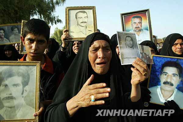 10月7日，在伊拉克纳杰夫，一些游行者拿着不明死亡亲人的照片哭诉。