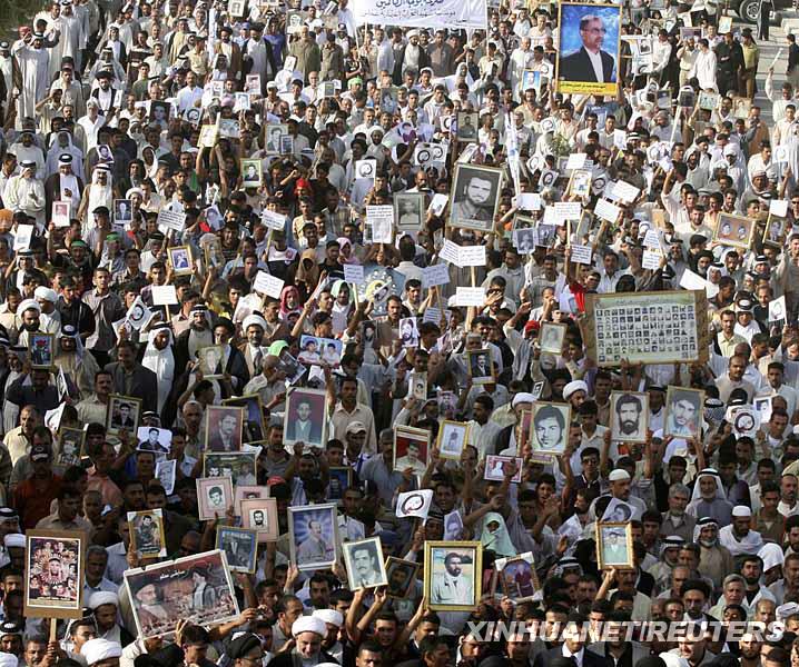 10月7日，在伊拉克納傑夫，人們舉著失蹤或已故親人的遺像參加遊行。