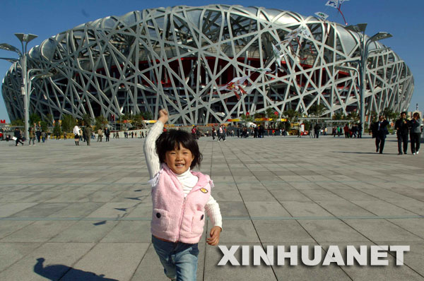 10月10日，来自南京的李欣蔓小朋友在奥林匹克公园内放风筝。 当日，北京奥林匹克公园正式免费对外开放，公众无需购票即可游园。 新华社记者公磊摄 