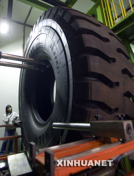 10月10日，技术人员在检测台上安装巨型子午线轮胎。 由天津赛象科技股份有限公司科研人员研发的国内目前最大的49/51特巨型工程子午线轮胎X光检测机近日在天津问世。该“巨无霸”X光机能给重达5吨的轮胎做“全身体检”，一次“体检”只需要7分钟。 新华社记者刘海峰摄 