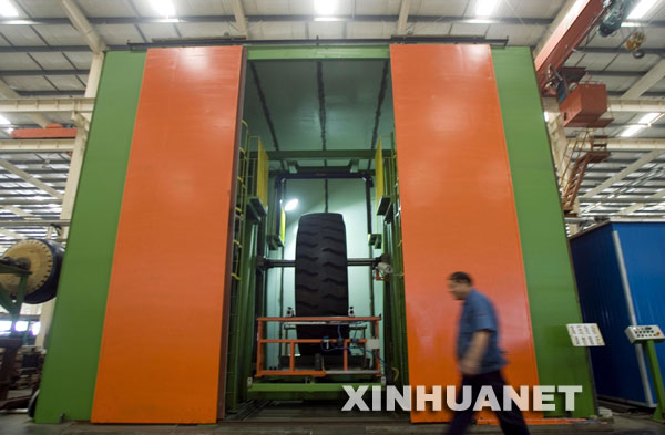 10月10日，一名技术人员从“巨无霸”X光机旁走过。 由天津赛象科技股份有限公司科研人员研发的国内目前最大的49/51特巨型工程子午线轮胎X光检测机近日在天津问世。该“巨无霸”X光机能给重达5吨的轮胎做“全身体检”，一次“体检”只需要7分钟。 新华社记者刘海峰摄 