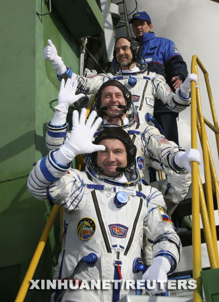 10月12日，在哈萨克斯坦的拜科努尔发射场，国际空间站第十八长期考察组的俄罗斯宇航员尤里·隆恰科夫（前一）、美国宇航员迈克·芬克（前二）和世界第六位太空游客、美国电脑游戏开发商理查德·加里奥特（前三）在登上飞船前向人们挥手。当日，国际空间站第十八长期考察组的俄罗斯宇航员尤里·隆恰科夫、美国宇航员迈克·芬克和世界第六位太空游客、美国电脑游戏开发商理查德·加里奥特乘坐俄罗斯“联盟TMA-13”载人飞船升空，前往国际空间站。 新华社/路透 