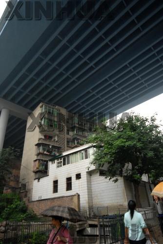  一栋6层楼房“藏身”在渝黔高速公路重庆南山段的高架桥下（5月30日摄）。钟桂林 摄（来源：中国图片总汇）