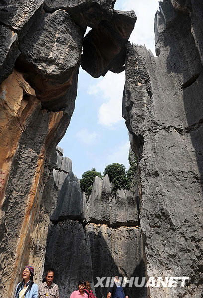 10月23日,游客在云南石林景区的千钧一发巨石下游览