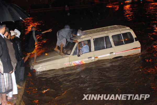 10月24日，在也门首都萨那一条被洪水淹没的路上，当地人帮助一名困在车里的外国游客。据也门通讯社当天报道，近几日持续暴雨引发的洪水和泥石流在也门东部的哈德拉毛省和马哈拉省造成46人死亡或失踪，数百座民房被冲毁，许多基础设施遭到破坏。 新华社/法新 