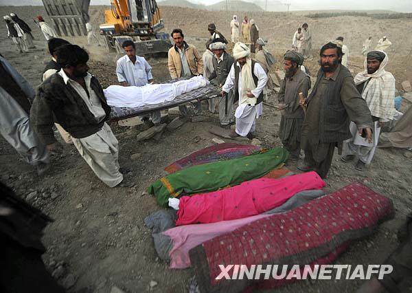  10月29日，在巴基斯坦西南部俾路支省首府奎達市以北約95公里的瓦姆村，當地村民在救援人員協助下掩埋地震遇難者的遺體。