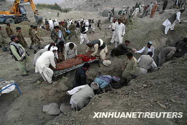 10月29日，在巴基斯坦西南部俾路支省地震重災區濟亞拉特，當地居民在救援隊伍幫助下掩埋遇難者遺體。
