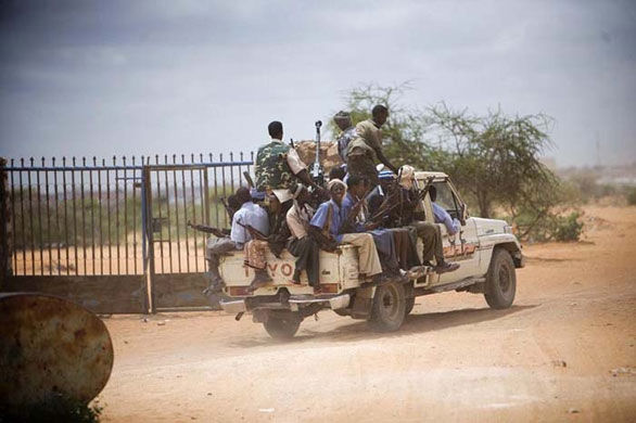 由于索马里安全局势不稳定，一切前往当地的外国游客被迫付高薪雇佣武装分子当“保镖”，护送车辆和人员免遭不明身份武装分子的袭击。图为摄影师韦罗妮克·德·维格里雇了15名荷枪实弹的武装分子。 