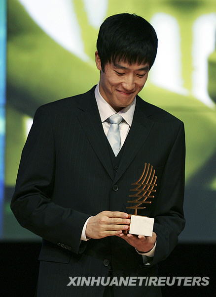 11月23日，中国选手刘翔在颁奖仪式上欣赏2006年度最佳表现奖奖杯。