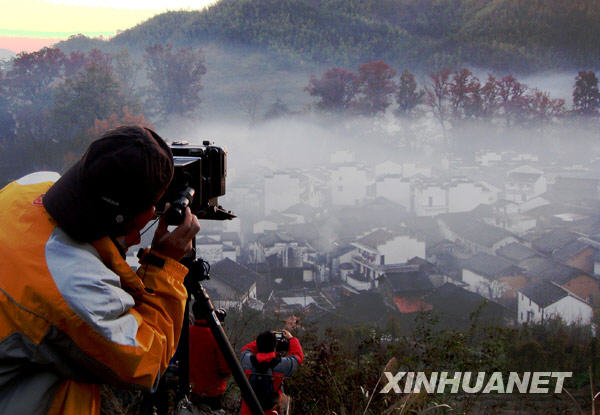  11月25日早晨，攝影愛好者在煙霧彌漫的婺源石城拍攝采風(fēng)。