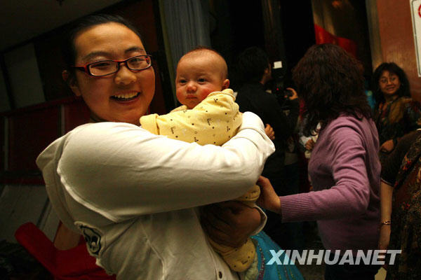 这是2008年2月25日，在北京举行的“首例试管婴儿诞生二十周年庆祝活动”上，郑萌珠怀抱一名4个月大的试管婴儿合影。