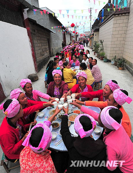 勐垅沙寨子里的傣族群众在长街宴上开怀畅饮(12月6日摄)