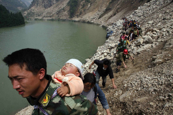 2008年5月16日，由于遭到地震袭击，清平村4000多村民没有水源和电力供应，整个村子被隔离。一名地震幸存者背着孩子与另外1000多名幸存者经过9小时步行，从清平村前往距离20公里外的汉旺镇。