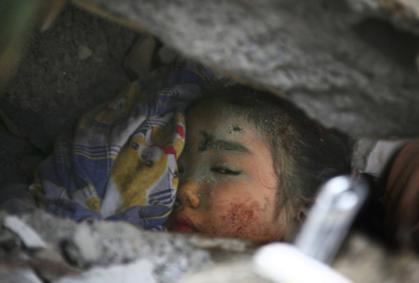 2008年5月13日，一个孩子被埋在北川县碎石中。中国派遣更多军队进入地震灾区，加速寻找被埋在废墟中的幸存者。