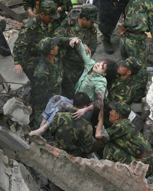 2008年5月13日，士兵们从北川县一栋倒塌的建筑物中抬出一名伤者。