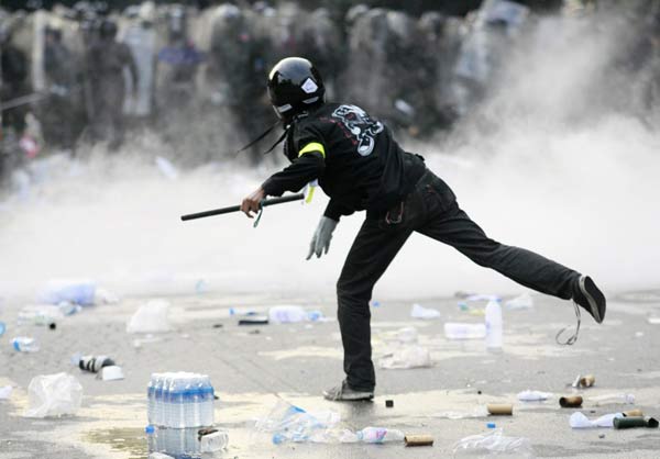 2008年10月7日，曼谷，一位男子向防暴警察投掷碎片。