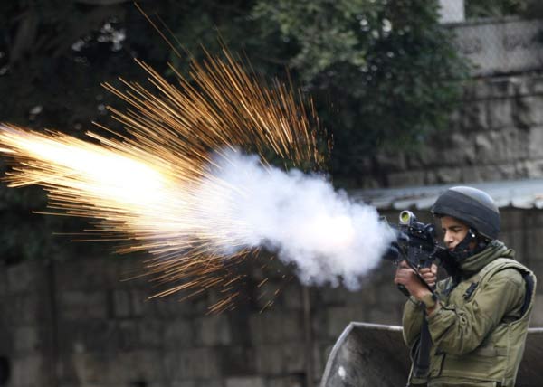 一名以色列士兵向投掷石块的巴勒斯坦人报以催泪瓦斯
