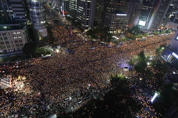 2008年6月10日，首尔中心区通往青瓦台总统府和美国大使馆的一条街道上，烛光守夜的抗议者呼喊着口号。