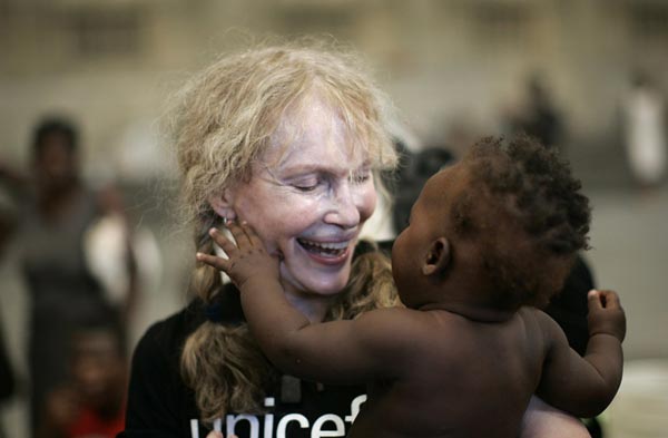 2008年9月20日，美国女星米亚•法罗作为联合国儿童基金会的慈善大使来到戈纳伊夫省难民营进行访问，图片中米亚正抱着一个海地婴儿微笑。 路透社/摄影 艾德华多•穆诺斯（海地）