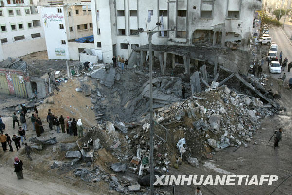 12月28日，一些巴勒斯坦人在加沙城查看一個以軍空襲留下的彈坑。以色列空軍27日開始針對加沙地帶多處目標進行空襲，目前已造成至少271人死亡、900多人受傷，其中120人傷勢嚴重。以色列方面稱這次行動是為了制止加沙巴勒斯坦武裝人員向以南部發射火箭彈。以國防部長巴拉克27日表示，如果需要，以軍將對加沙地帶發動地面攻勢。