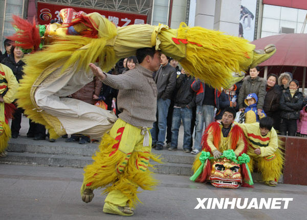 1月1日，河北白沟市民间舞狮队在市中心舞狮以迎新年，队员使出舞狮绝活“狮子横飞”，观者赞叹不已。 新华社记者 张燕辉 摄 