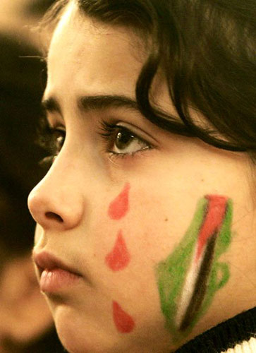 和平/一个脸上画着国旗的巴勒斯坦小女孩在为和平祈祷。...