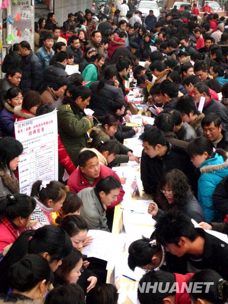 2月4日，在怀远县劳动力市场，返乡农民工在招聘会上与用工单位代表洽谈。 
