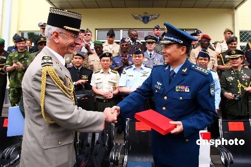 图为中国空军刘明豹(右)大校与驻华武官团团长谢贝德上校互赠礼物.