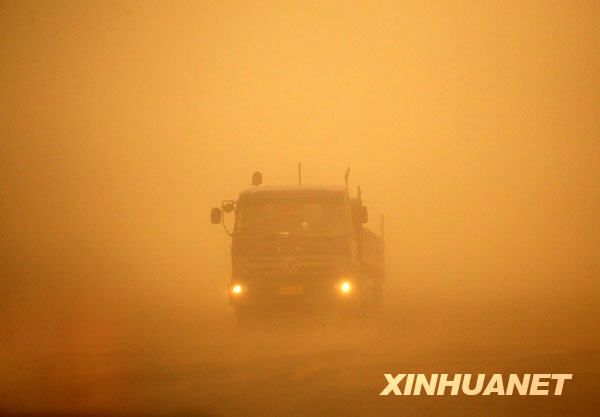 4月29日，在甘肃省敦煌市，一辆货车在风沙中行驶。
