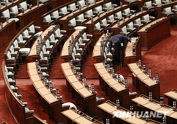  7月21日，在日本国会众议院，一位安保人员在众议院解散后将座椅上竖立的议员姓名牌放倒
