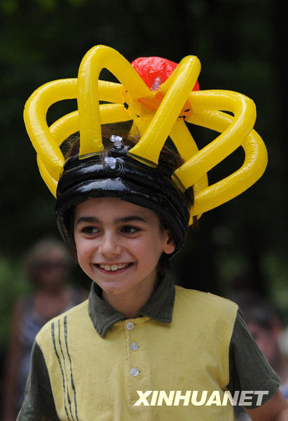  7月21日，在比利时首都布鲁塞尔市中心，一名儿童头戴比利时国旗三种颜色的玩具参加国庆节庆祝活动。