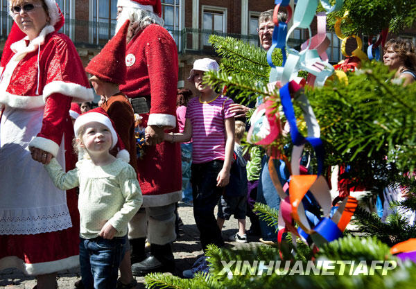  7月21日，在丹麦首都哥本哈根，打扮成圣诞老人和小精灵的人们参加2009世界圣诞老人大会