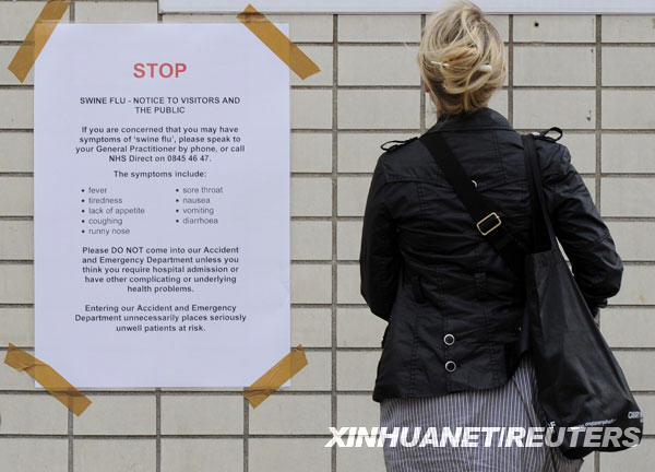 7月22日，一名妇女在英国首都伦敦一所医院外阅读甲型H1N1流感公告