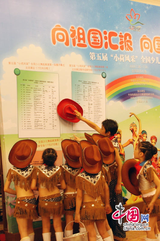 7月26日晚，第五届“小荷风采”全国少儿舞蹈展演在北京全国政协礼堂拉开帷幕。赛前小演员们聚集在展板前查看节目次序。