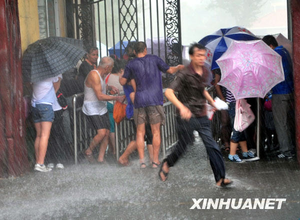 8月2日，天津市民在暴雨中紧急避雨。当日下午，一场倾盆暴雨突袭天津，使街上的许多市民避之不及。强降雨虽然给出行造成不便，但也送来了清凉。