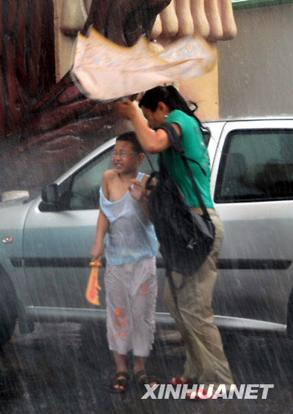 8月2日，天津市民在暴雨中紧急避雨。当日下午，一场倾盆暴雨突袭天津，使街上的许多市民避之不及。强降雨虽然给出行造成不便，但也送来了清凉。