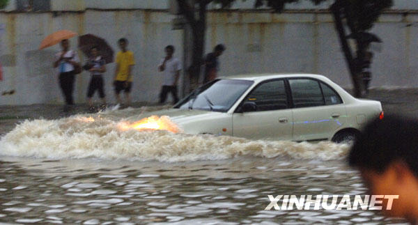 8月6日，一辆汽车在海口市区主干道涉水行驶。
