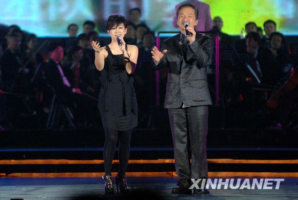  8月6日，成龙（右）、林忆莲合唱奥运一周年纪念活动主题曲《恍然如梦》。当日，“奥运华章献祖国”纪念北京奥运会成功举办一周年音乐会在北京奥林匹克森林公园举行。