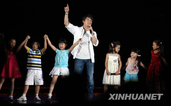 8月6日，歌手周华健（中）与李木子等小朋友演唱歌曲《我是明星》。当日，“奥运华章献祖国”纪念北京奥运会成功举办一周年音乐会在北京奥林匹克森林公园举行。