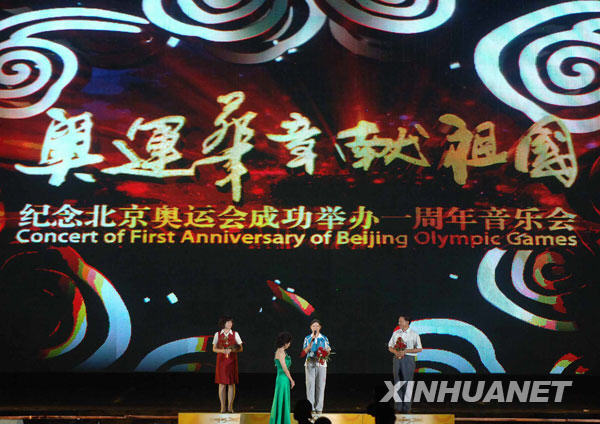 8月6日，奥运工作人员代表（左一）、志愿者代表（右二）、建设者代表（右一）接受献花。当日，“奥运华章献祖国”纪念北京奥运会成功举办一周年音乐会在北京奥林匹克森林公园举行。
