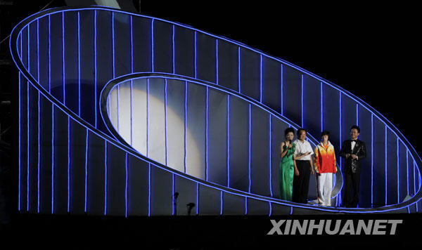 8月6日，中国奥运史上第一枚金牌得主许海峰（左二）和奥运会中国第100枚金牌得主张怡宁（左三）在音乐会上谈参加奥运会的感受。当日，“奥运华章献祖国”纪念北京奥运会成功举办一周年音乐会在北京奥林匹克森林公园举行。