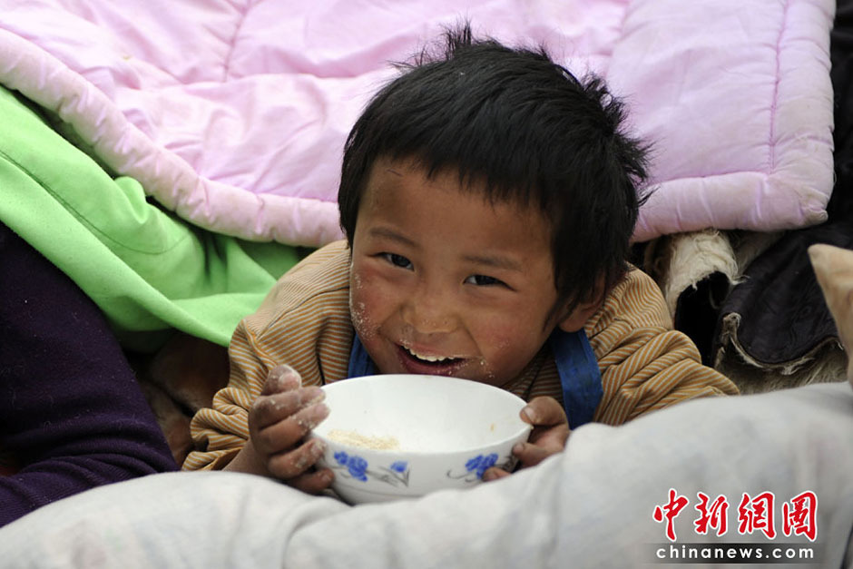 在地震中受伤的小男孩目光清澈,却满脸伤痕。